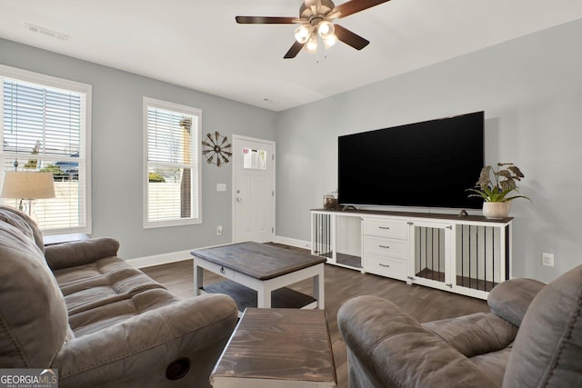 living area with dark wood-style floors, baseboards, visible vents, and ceiling fan