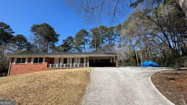 single story home featuring covered porch, brick siding, driveway, crawl space, and a carport