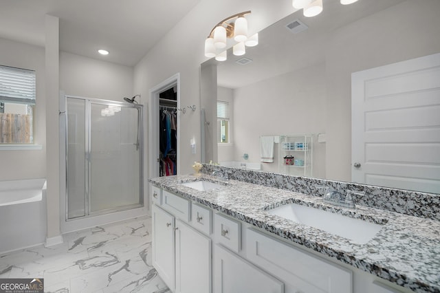 bathroom with a stall shower, marble finish floor, visible vents, and a sink