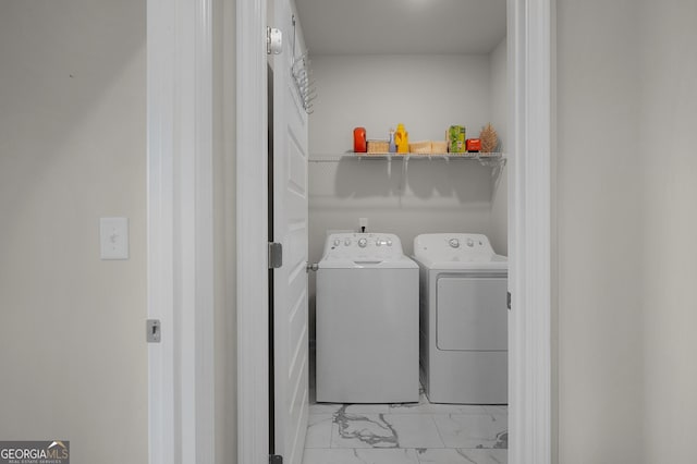 laundry area featuring marble finish floor, washer and clothes dryer, and laundry area