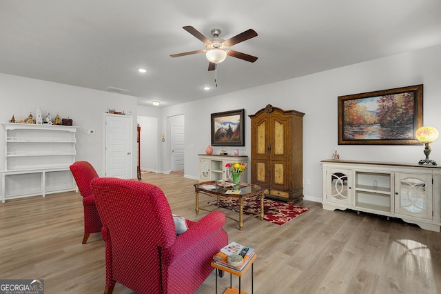 living room with light wood finished floors, visible vents, and baseboards