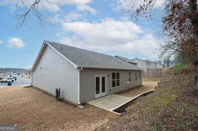 back of property featuring a patio, roof with shingles, and fence