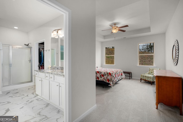 bedroom featuring baseboards, a raised ceiling, marble finish floor, a spacious closet, and recessed lighting