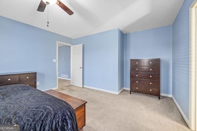 bedroom featuring visible vents, light colored carpet, a ceiling fan, a textured ceiling, and baseboards