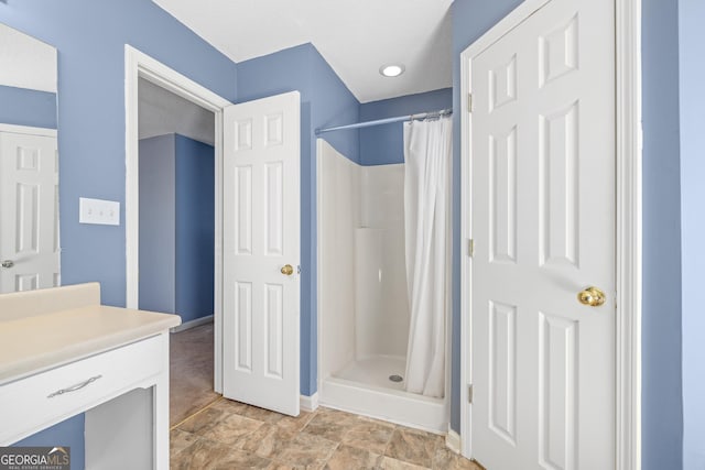 bathroom with a stall shower, baseboards, vanity, and a textured ceiling