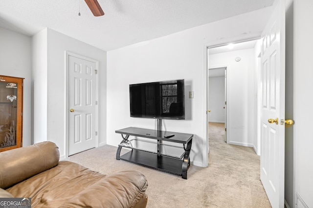 living room with visible vents, baseboards, light colored carpet, ceiling fan, and a textured ceiling