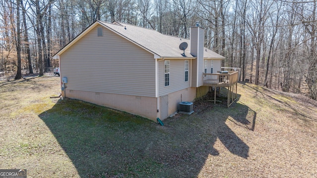 view of side of home featuring crawl space, a lawn, and a wooden deck