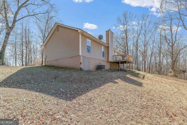 view of side of property with central AC, crawl space, a chimney, and a wooden deck