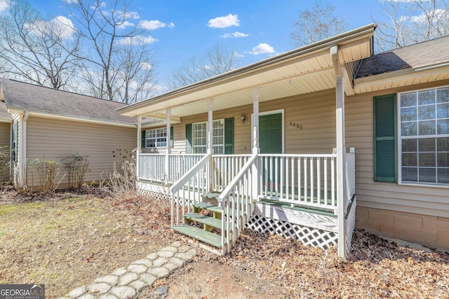 property entrance featuring a porch and a shingled roof