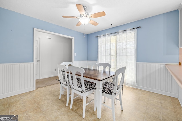 dining room featuring a wainscoted wall and a ceiling fan