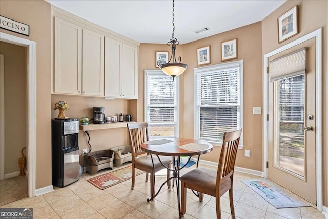 dining space featuring light tile patterned flooring, visible vents, and baseboards