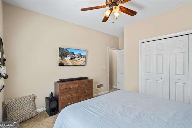 bedroom featuring a closet, light colored carpet, visible vents, a ceiling fan, and baseboards