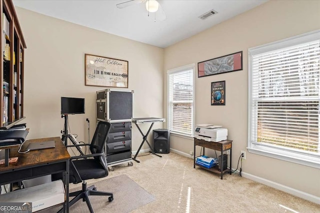 home office featuring light colored carpet, visible vents, ceiling fan, and baseboards