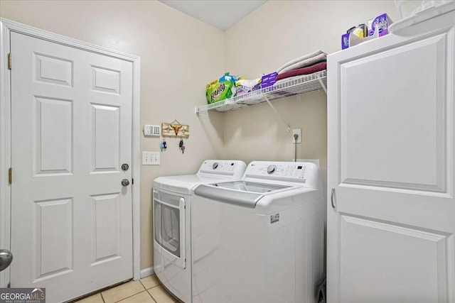 washroom featuring light tile patterned floors, laundry area, and washing machine and dryer