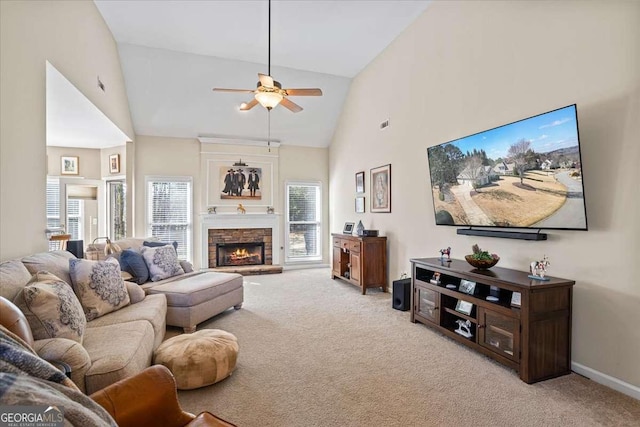 living room featuring ceiling fan, high vaulted ceiling, light colored carpet, a fireplace, and baseboards