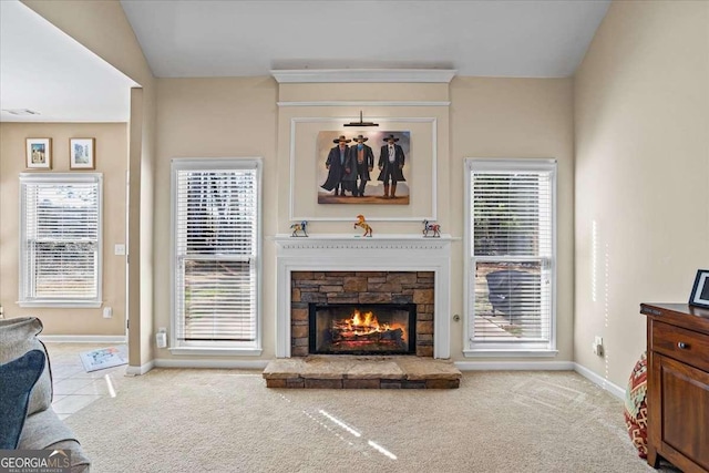 living area with vaulted ceiling, a fireplace, baseboards, and light colored carpet