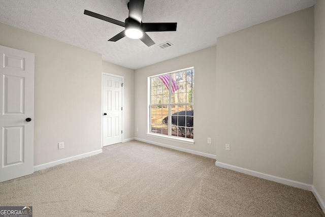 unfurnished bedroom with baseboards, visible vents, ceiling fan, a textured ceiling, and carpet flooring