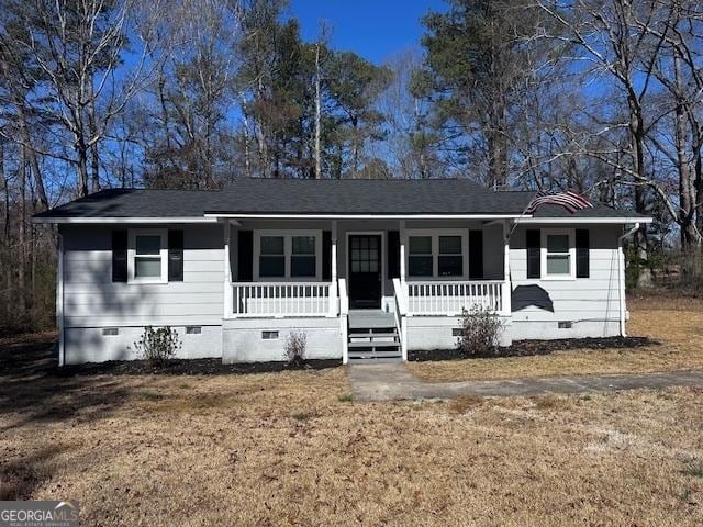 view of front of property with a shingled roof, a front yard, crawl space, and covered porch