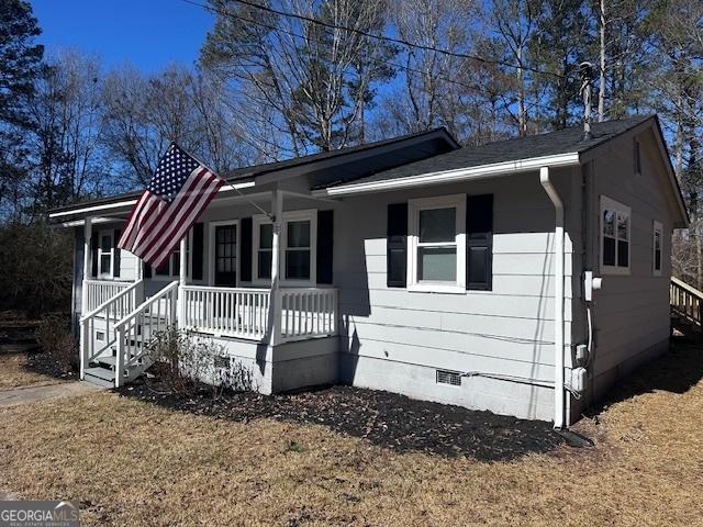 view of front of property with a porch, crawl space, and a front lawn