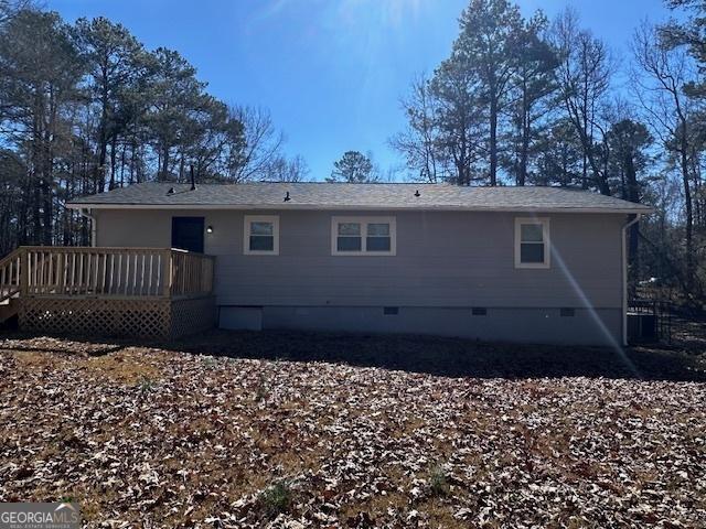 rear view of house featuring crawl space and a deck