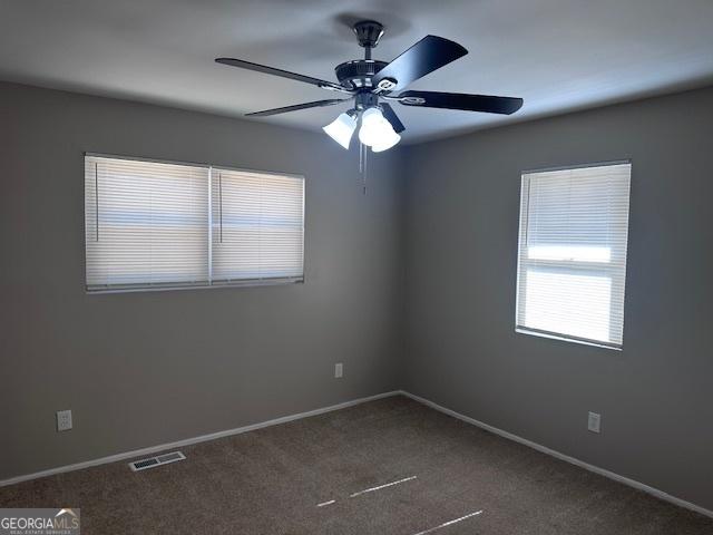 spare room featuring a ceiling fan, carpet flooring, visible vents, and baseboards