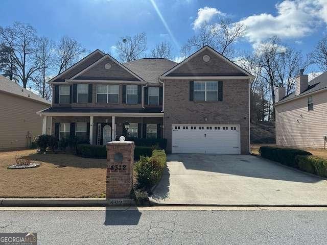 view of front of home with a garage, driveway, and covered porch