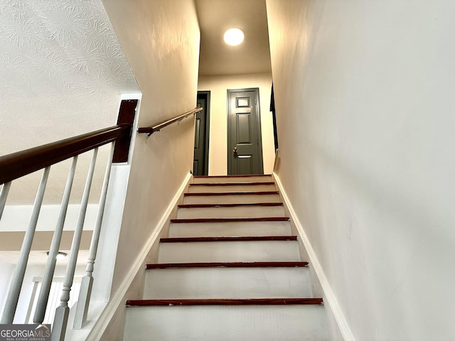 stairway featuring baseboards