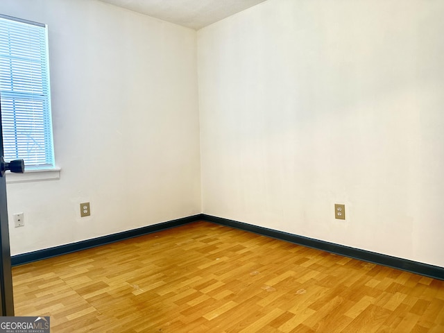 empty room with baseboards and light wood finished floors