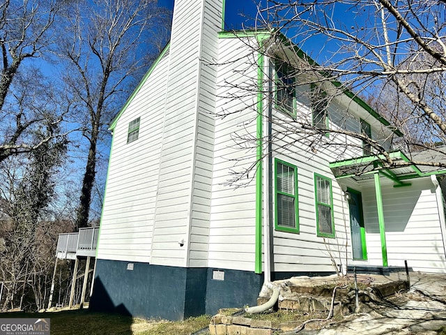 view of side of property featuring crawl space and a chimney