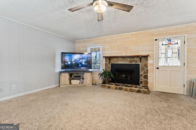 unfurnished living room with a textured ceiling, carpet floors, a ceiling fan, and crown molding