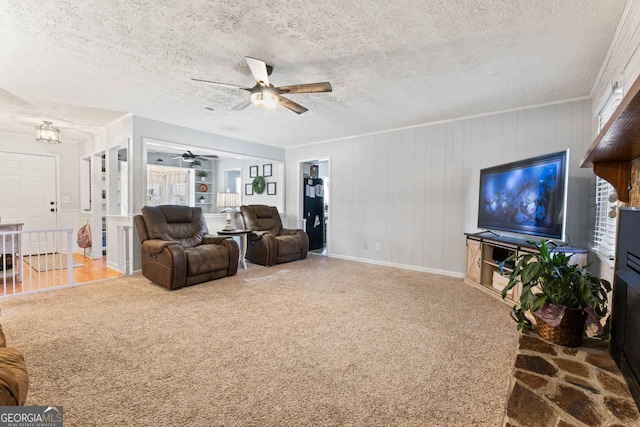 living room featuring a textured ceiling, carpet flooring, a ceiling fan, and baseboards