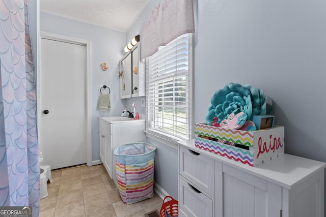 bathroom with a textured ceiling, vanity, and tile patterned floors