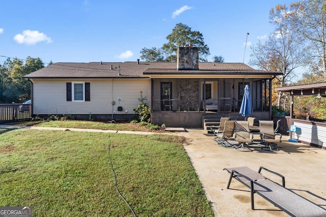 rear view of property with a yard, a patio, and a chimney