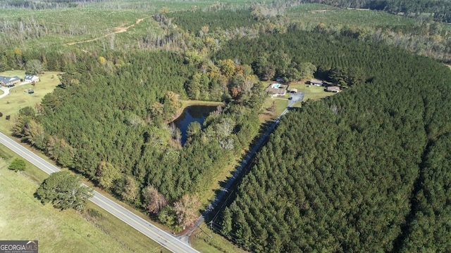 drone / aerial view with a water view and a forest view