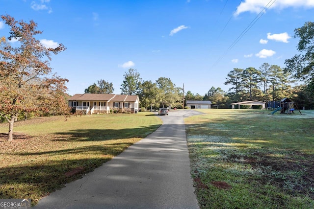 view of front facade with playground community and a front lawn