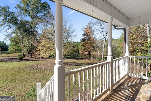 wooden terrace with covered porch and a lawn