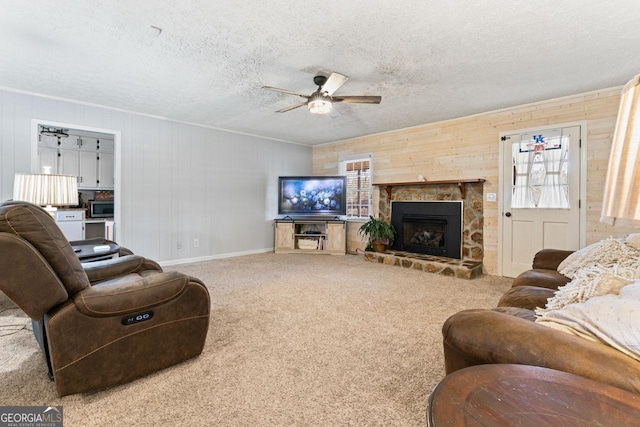 carpeted living room with baseboards, a fireplace, a ceiling fan, and a textured ceiling