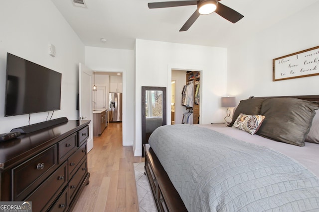 775 Juniper St NE Unit 613, Atlanta, GA 30308 - bedroom featuring stainless steel refrigerator with ice dispenser, a spacious closet, light wood-type flooring, ceiling fan, and a closet