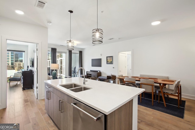 775 Juniper St NE Unit 613, Atlanta, GA 30308 - kitchen featuring stainless steel dishwasher, open floor plan, an island with sink, light wood-style floors, and recessed lighting