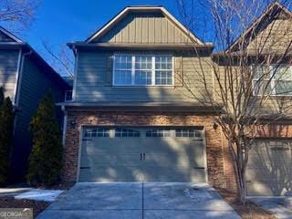 view of front facade with driveway, brick siding, and an attached garage