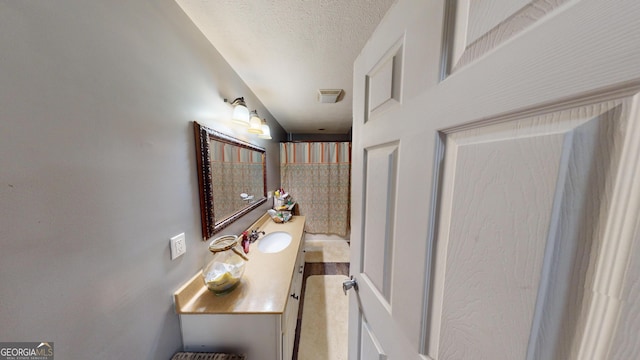 bathroom featuring a textured ceiling and vanity