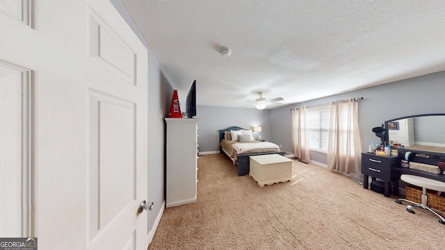 bedroom with a ceiling fan, a textured ceiling, baseboards, and carpet flooring