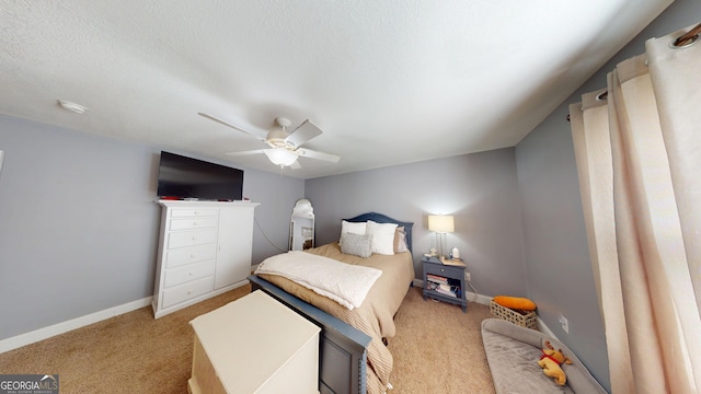 carpeted bedroom featuring ceiling fan, baseboards, and a textured ceiling