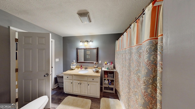 full bathroom with visible vents, a textured ceiling, and vanity