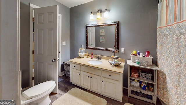 full bathroom featuring toilet, wood finished floors, and vanity