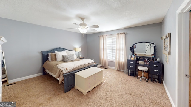 bedroom featuring light carpet, a textured ceiling, and baseboards