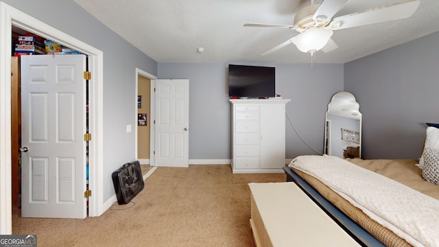 bedroom with light carpet, baseboards, and a ceiling fan