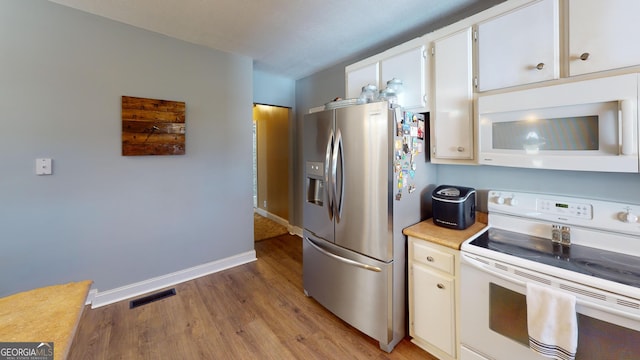 kitchen featuring white appliances, visible vents, white cabinets, light countertops, and light wood-type flooring