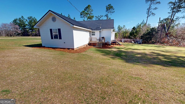 rear view of house with a yard, crawl space, and metal roof