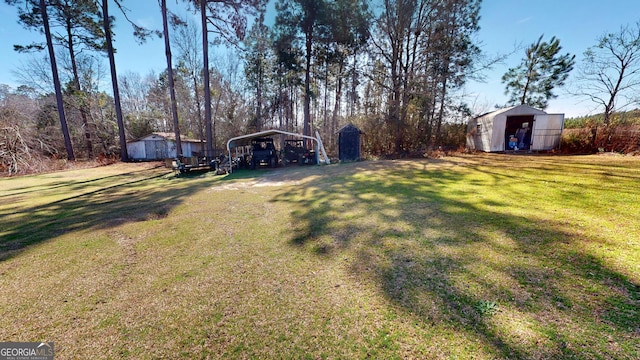 view of yard featuring an outbuilding, a carport, and driveway